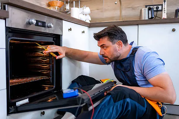 Technician repairing oven and stove with warranty service in salem