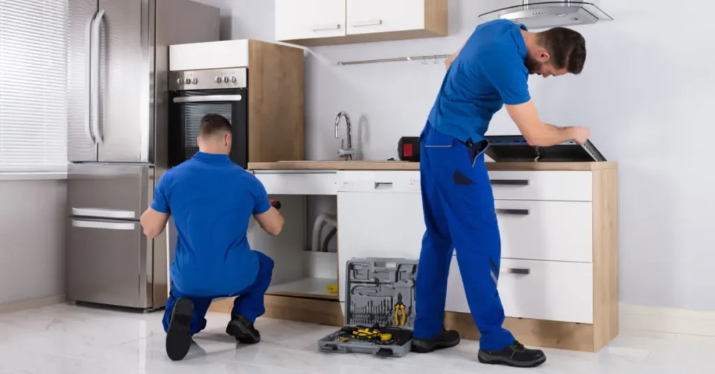 Two technician repairing garbage disposal disposal system under kitchen sink